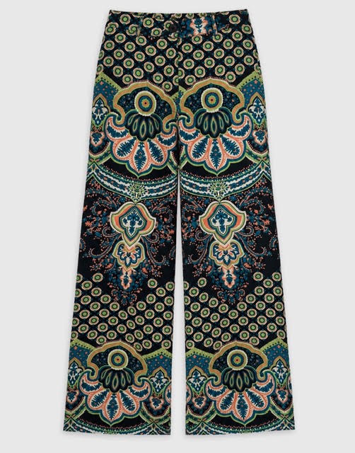 Wide-leg pants featuring an intricate, symmetrical bohemian mandala pattern in black, teal, green, and coral pink, displayed flat against a light gray background.